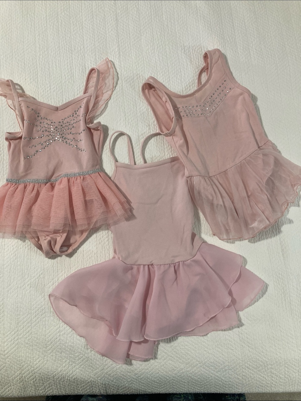 Trío of pink ballet leotards with attached skirts